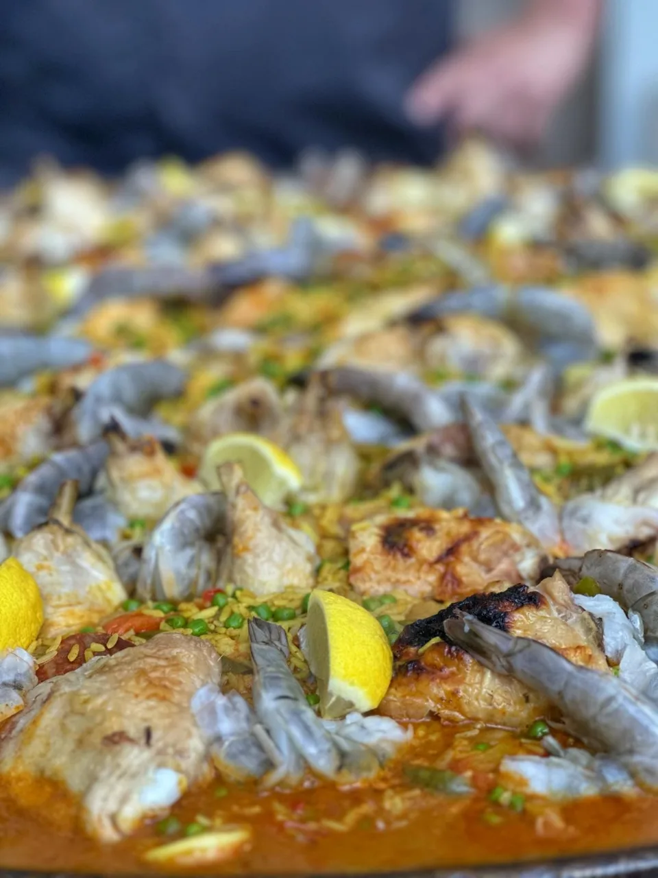 Gros plan sur une paella cuite à la plancha avec gambas, poissons et rondelles de citron